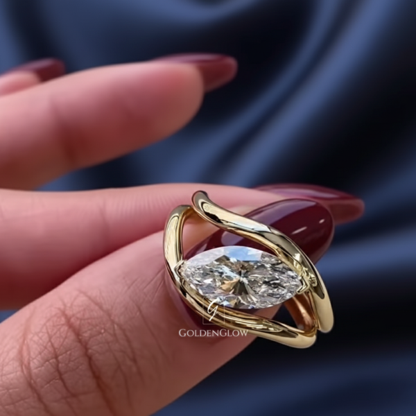 oval solitaire ring, oval diamond ring, marquise style setting, modern engagement ring, yellow gold ring, gold solitaire ring, minimalist engagement ring, unique bridal ring, bypass ring, contemporary ring design, lab grown diamond ring, moissanite ring, elegant ring, fine jewelry, anniversary ring, wedding ring, custom made ring, luxury ring, modern bride ring