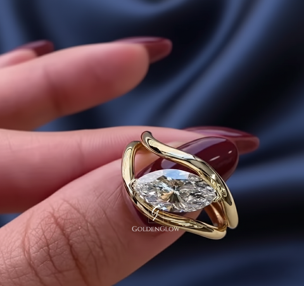 oval solitaire ring, oval diamond ring, marquise style setting, modern engagement ring, yellow gold ring, gold solitaire ring, minimalist engagement ring, unique bridal ring, bypass ring, contemporary ring design, lab grown diamond ring, moissanite ring, elegant ring, fine jewelry, anniversary ring, wedding ring, custom made ring, luxury ring, modern bride ring