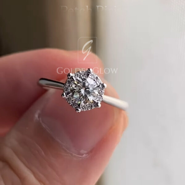 Rear view of a round diamond engagement ring showcasing the open gallery and pavé diamonds along the bridge beneath the center stone. The polished white metal band forms a clean circle, while the under-setting reveals fine detailing and symmetry. This image emphasizes ring construction, durability, and artisan finishing.