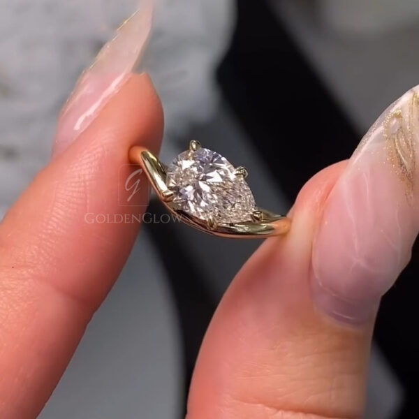 A detailed side angle capturing the ring's dual-texture design. The top of the yellow gold band features sparkling pavé-set diamonds, while the sides are hand-engraved with vintage scrolls. The pear-cut lab grown diamond or Moissanite is held securely, with a V-tip prong protecting the point. This image emphasizes the complexity of the design and the layered sparkle from both the center stone and the band accents.