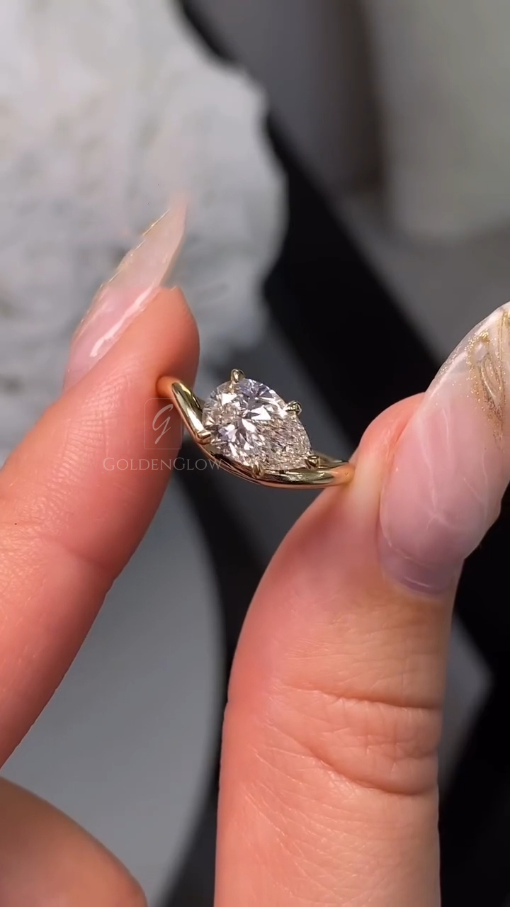 A detailed side angle capturing the ring's dual-texture design. The top of the yellow gold band features sparkling pavé-set diamonds, while the sides are hand-engraved with vintage scrolls. The pear-cut lab grown diamond or Moissanite is held securely, with a V-tip prong protecting the point. This image emphasizes the complexity of the design and the layered sparkle from both the center stone and the band accents.